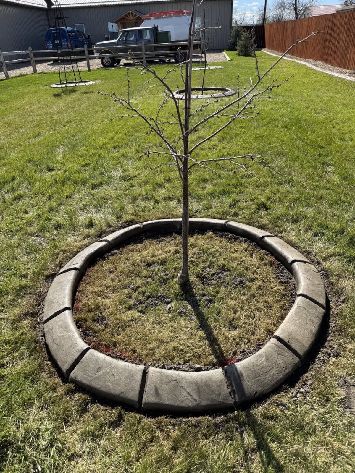 Residential curbing around garden beds with decorative rock and plantings